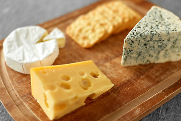 Image showing different cheeses and crackers on wooden board