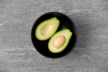 Image showing close up of ripe avocado with bone in ceramic bowl