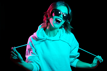 Image showing woman wearing hoodie in neon lights over black