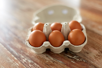 Image showing close up of eggs in cardboard box on wooden table
