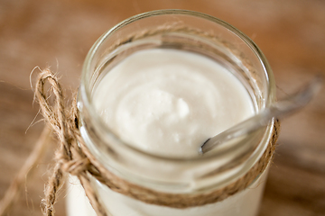 Image showing yogurt or sour cream in glass jar on wooden table