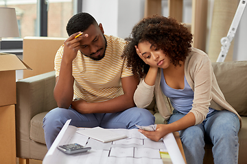 Image showing sad couple with blueprint counting money at home