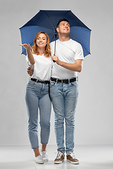 Image showing happy couple in white t-shirts with umbrella