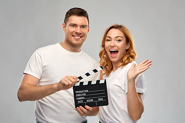 Image showing happy couple in white t-shirts with clapperboard