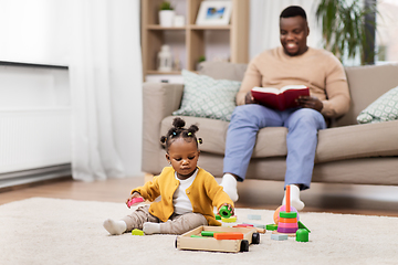 Image showing african baby girl playing with toy blocks at home