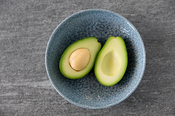 Image showing close up of ripe avocado with bone in ceramic bowl