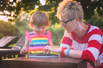 Image showing mom and her little daughter using tablet computer