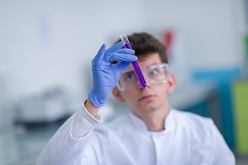 Image showing student with protective glasses making chemistry experiment