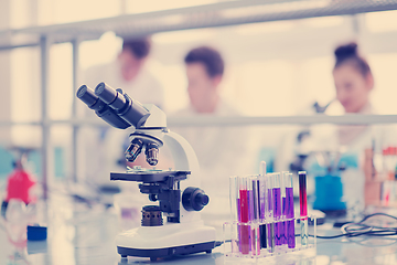 Image showing Microscope on the workplace near test tubes