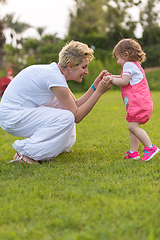 Image showing mother and little daughter playing at backyard