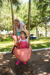 Image showing mother and daughter swinging in the park