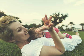 Image showing mother and little daughter playing at backyard