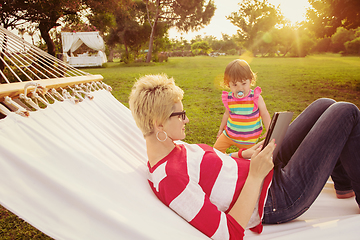 Image showing mom and a little daughter relaxing in a hammock