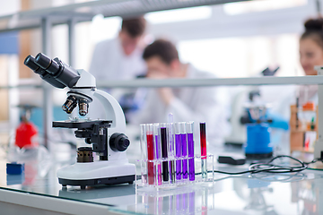 Image showing Microscope on the workplace near test tubes