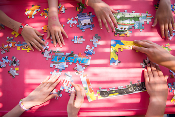 Image showing top view of kids hands playing with puzzles