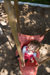 Image showing little girl swinging  on a playground