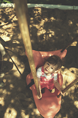 Image showing little girl swinging  on a playground