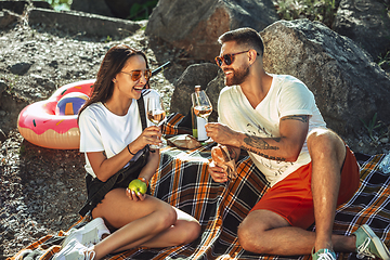 Image showing Young couple having picnic at riverside in sunny day