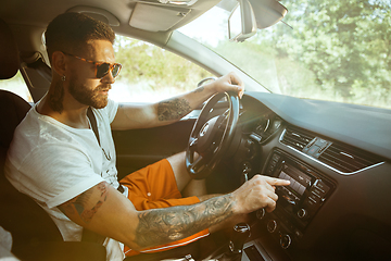 Image showing Young man preparing for vacation trip on the car in sunny day