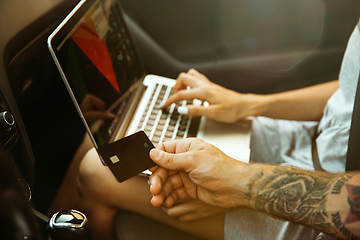 Image showing Young couple preparing for vacation trip on the car in sunny day