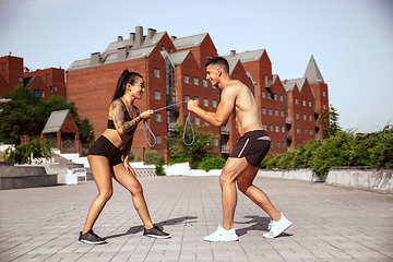 Image showing A muscular athletes doing workout on the city\'s street or park