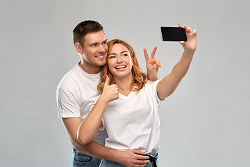 Image showing happy couple in white t-shirts taking selfie