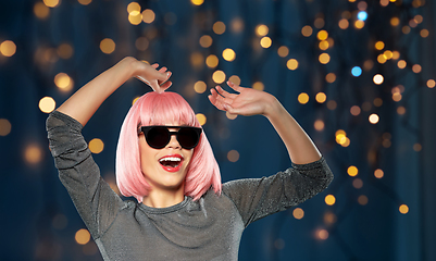 Image showing happy woman in pink wig and sunglasses dancing