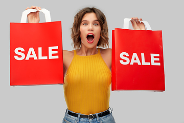 Image showing surprised young woman with shopping bags on sale