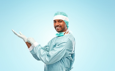 Image showing indian male doctor or surgeon putting glove on