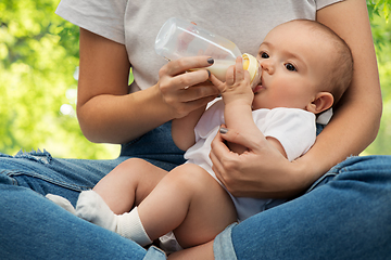 Image showing close up of mother feeding baby with milk formula