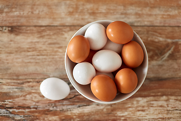 Image showing close up of eggs in ceramic bowl on wooden table