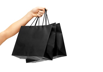 Image showing female hand holding black shopping bags