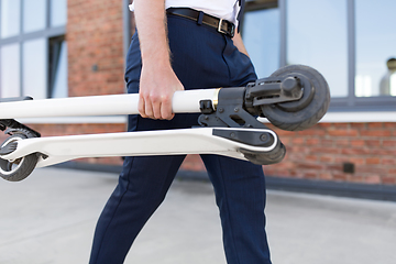 Image showing businessman with folding scooter on rooftop