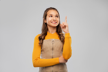 Image showing smiling young teenage girl pointing finger up