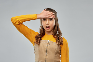 Image showing shocked young teenage girl holding to her head