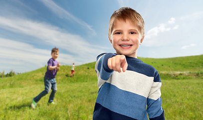 Image showing little boy pointing finger to camera outdoors