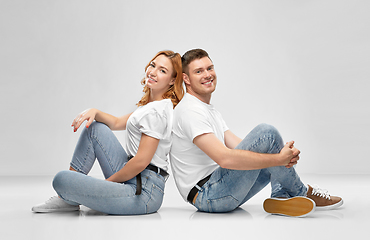 Image showing happy couple in white t-shirts sitting on floor