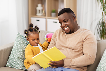 Image showing african father reading book for baby daughter