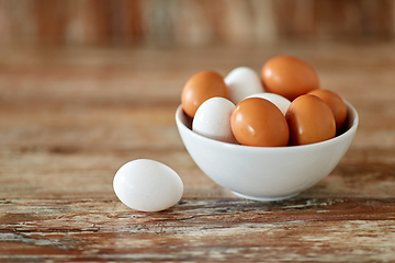 Image showing close up of eggs in ceramic bowl on wooden table