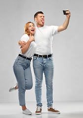 Image showing happy couple in white t-shirts taking selfie