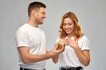 Image showing happy couple in white t-shirts with christmas gift