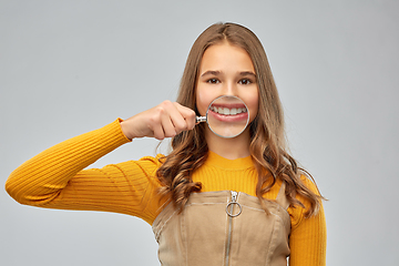 Image showing teenage girl shows teeth through magnifying glass