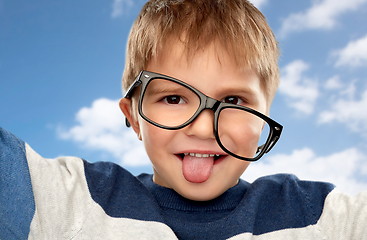Image showing portrait of little boy in glasses showing tongue