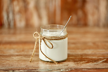 Image showing yogurt or sour cream in glass jar on wooden table