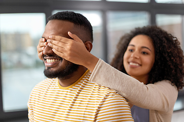 Image showing happy african american woman closing man\'s eyes