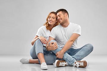 Image showing happy couple in white t-shirts sitting on floor