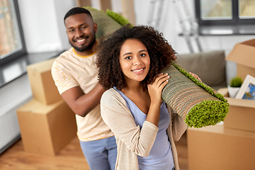 Image showing happy couple with carpet moving to new home