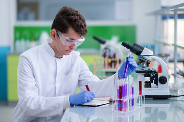 Image showing student with protective glasses making chemistry experiment