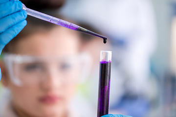 Image showing female student with protective glasses making chemistry experime