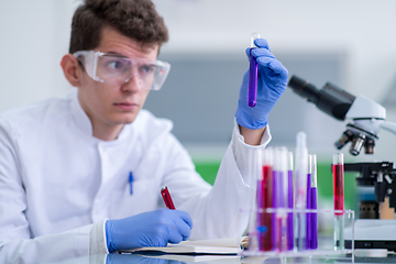 Image showing student with protective glasses making chemistry experiment